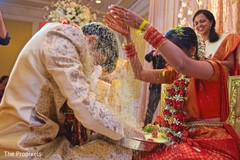 Indian Bride pours rice into the Raja's head. Indian Bride pours rice into the Raja's head.