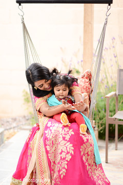 Lovely Indian bride with family member watching her henna art on her hands. Lovely Indian bride with family member watching her henna art on her hands.