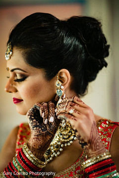 Indian bride putting earrings on Indian bride putting earrings on