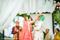 Indian bride putting flower garland to groom. Indian bride putting flower garland to groom.