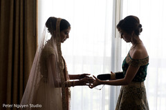 Indian bride being helped with jewelry Indian bride being helped with jewelry