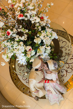 Indian couple kiss in front of the beautiful flower arrangement. Indian couple kiss in front of the beautiful flower arrangement.