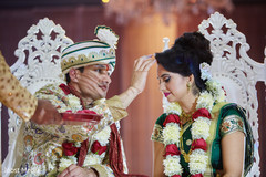Indian groom putting red dot to bride ritual. Indian groom putting red dot to bride ritual.