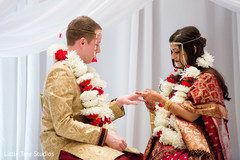 Indian bride putting wedding ring on groom Indian bride putting wedding ring on groom