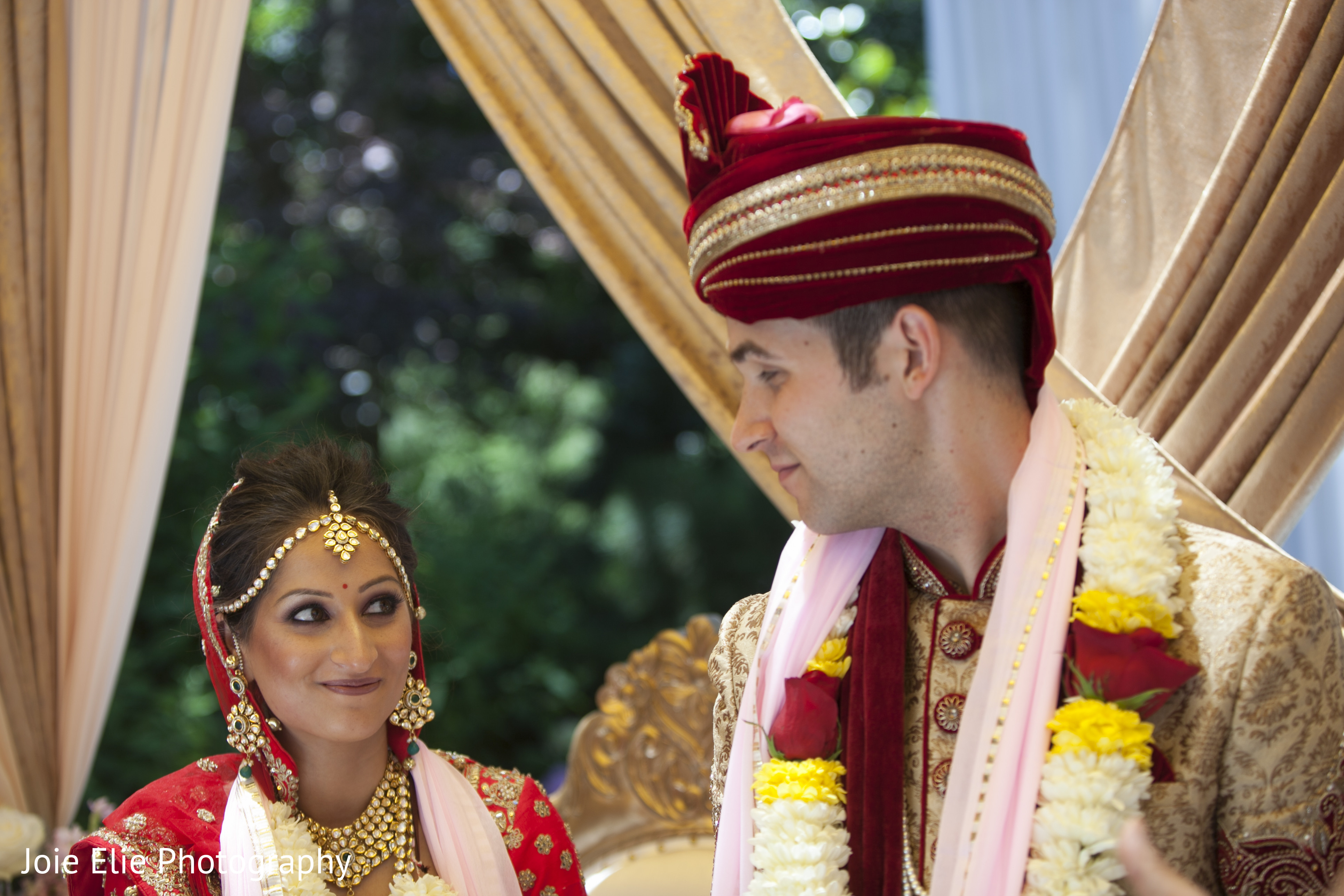 Indian couple look at each other as the ceremony continues | Photo 189347