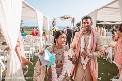 Indian bride and groom walking down the aisle out from the ceremony. Indian bride and groom walking down the aisle out from the ceremony.