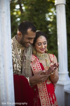 Capture of the Indian couple outdoors as they look at the mehndi design Capture of the Indian couple outdoors as they look at the mehndi design