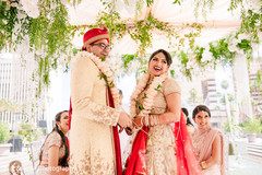 Indian couple hold hands as they smile during the wedding Indian couple hold hands as they smile during the wedding