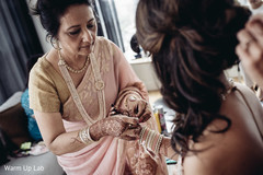 Marvelous Indian bride being helped with Hath Panja bracelet. Marvelous Indian bride being helped with Hath Panja bracelet.