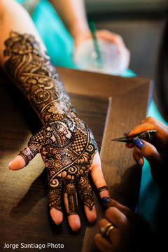 Mehndi artist working on the beautiful design on the maharani Mehndi artist working on the beautiful design on the maharani