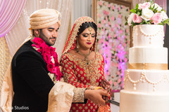 Indian lovebirds cutting their wedding cake Indian lovebirds cutting their wedding cake