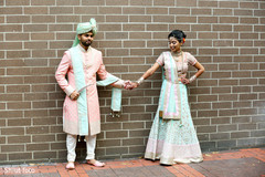 Indian bride and groom pose for pictures while holding hands Indian bride and groom pose for pictures while holding hands