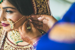 Indian bride putting earrings on Indian bride putting earrings on