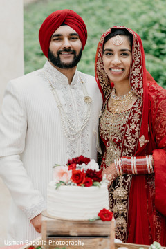 Dazzling portrait of the Indian newlyweds in front of the cake Dazzling portrait of the Indian newlyweds in front of the cake