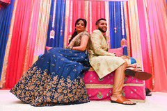Indian bride and groom at the colorful Indian sangeet stage decoration. Indian bride and groom at the colorful Indian sangeet stage decoration.