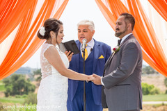 Marriage officiant performing the ceremony as the Indian couple listen Marriage officiant performing the ceremony as the Indian couple listen