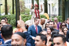Cheerful Indian groom greeting guests during the baraat Cheerful Indian groom greeting guests during the baraat