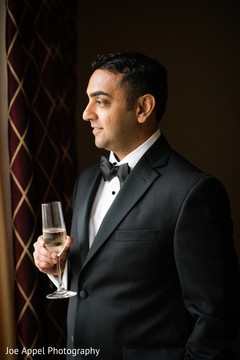 Indian groom posing for pictures holding his drink Indian groom posing for pictures holding his drink