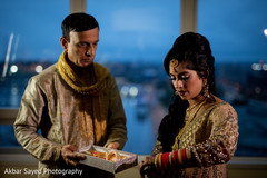 Beautiful Indian bride being assisted with the bridal jewelry Beautiful Indian bride being assisted with the bridal jewelry