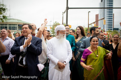 Indian wedding guests dance and observe the baraat Indian wedding guests dance and observe the baraat
