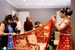 Indian bride being assisted with her bridal wear Indian bride being assisted with her bridal wear