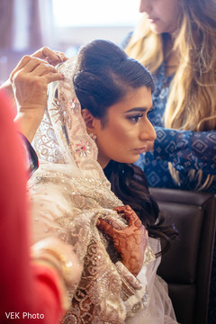 Enchanting Indian bride getting her wedding ghunghat veil on.