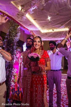 Indian bride holding the bouquet walks to the aisle Indian bride holding the bouquet walks to the aisle