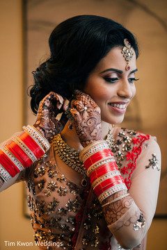Indian bride putting her earrings on Indian bride putting her earrings on