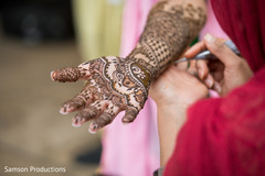 Mehndi artist working on the bride's arm Mehndi artist working on the bride's arm