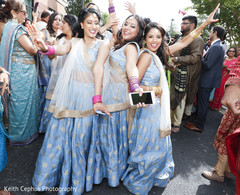 Indian bridesmaids posing for pictures during the baraat Indian bridesmaids posing for pictures during the baraat