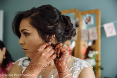 Indian bride putting earrings on. Indian bride putting earrings on.
