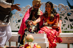 Indian bride and groom pouring into sacred fire Indian bride and groom pouring into sacred fire