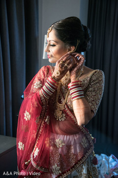 Indian bride putting on her earrings Indian bride putting on her earrings