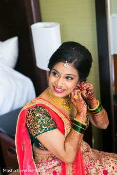 Indian bride putting on her earrings Indian bride putting on her earrings