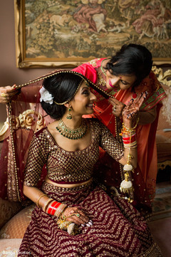 Indian bride being assisted by her mother with the accessories Indian bride being assisted by her mother with the accessories