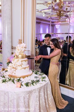 Lovely capture Indian bride and groom cutting cake together. Lovely capture Indian bride and groom cutting cake together.
