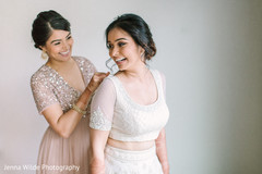 Sweet indian bride's relative helping her to get ready. Sweet indian bride's relative helping her to get ready.