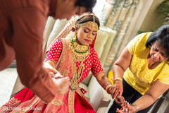 Indian bride getting help while getting ready Indian bride getting help while getting ready