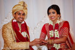 Indian groom putting wedding ring on bride Indian groom putting wedding ring on bride