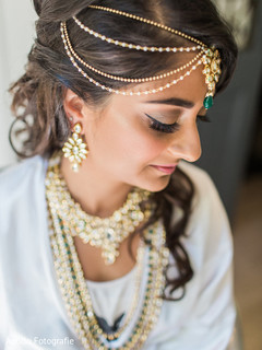 Indian bride wearing the tikka as she gets ready Indian bride wearing the tikka as she gets ready