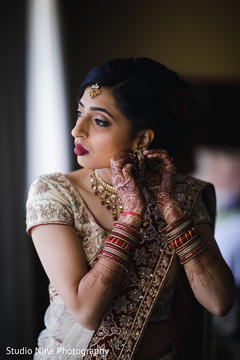 Dazzling Indian bride putting her earrings on. Dazzling Indian bride putting her earrings on.