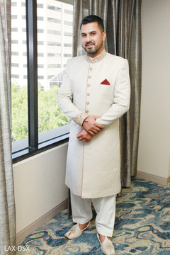 Indian groom wearing the sherwani before the rituals Indian groom wearing the sherwani before the rituals