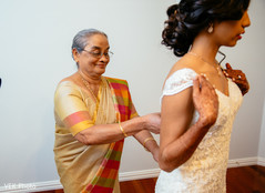 Indian bride being helped by special guest before the ceremony Indian bride being helped by special guest before the ceremony