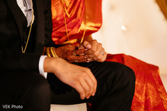 Indian bride and groom holding hands during the ceremony Indian bride and groom holding hands during the ceremony