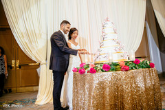 Indian newlyweds cutting the wedding cake Indian newlyweds cutting the wedding cake