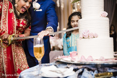 Indian bride and groom using the kirpan to cut the cake Indian bride and groom using the kirpan to cut the cake