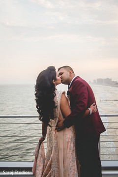 Indian bride and groom kissing by the sea Indian bride and groom kissing by the sea