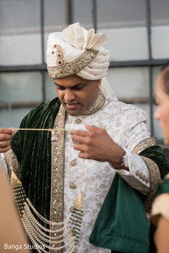 Indian groom putting his mala necklace. Indian groom putting his mala necklace.