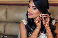 Indian bride putting earrings on. Indian bride putting earrings on.