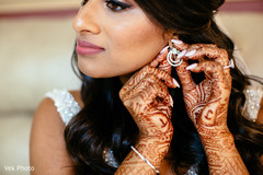 Dazzling Indian bride putting her earrings on. Dazzling Indian bride putting her earrings on.